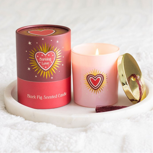 Pink scented candle with a red cylindrical container on a white background